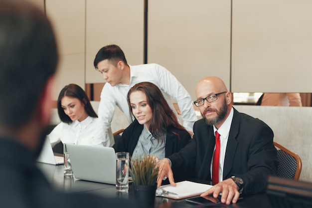 Pessoas de negócios, trabalhando juntos na mesa de conferência