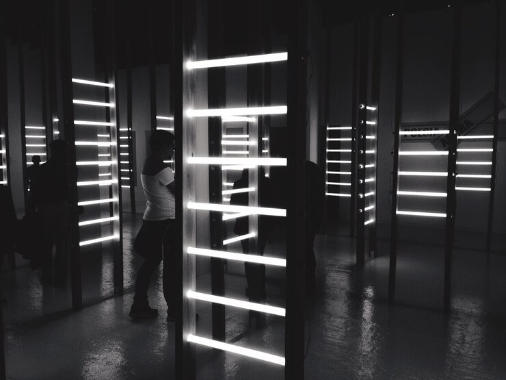 Foto pessoas de pé numa sala iluminada no museu da língua portuguesa