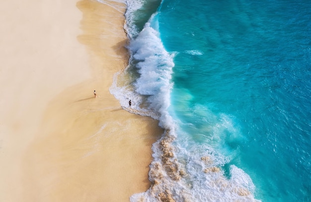 Pessoas de praia e ondas Costa como pano de fundo da vista superior Fundo de água azul do drone Paisagem marítima de verão do ar Nusa Penida island Indonésia Travel image