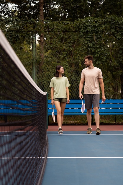 Foto pessoas de tiro completo no campo de badminton