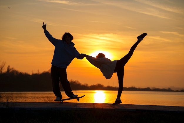 Pessoas de tiro completo posando ao pôr do sol