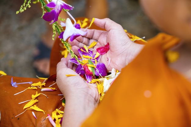 Pessoas derramando água para monges budistas e dá a bênção na Tailândia Songkran festival anual no templo budista