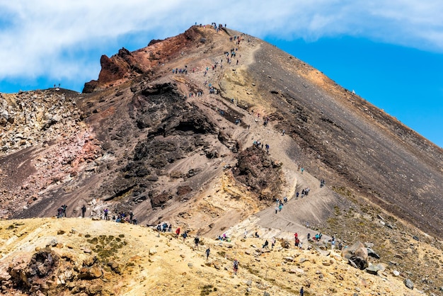 Foto pessoas descendo da cratera vermelha para os lagos esmeralda na travessia alpina de tongariro