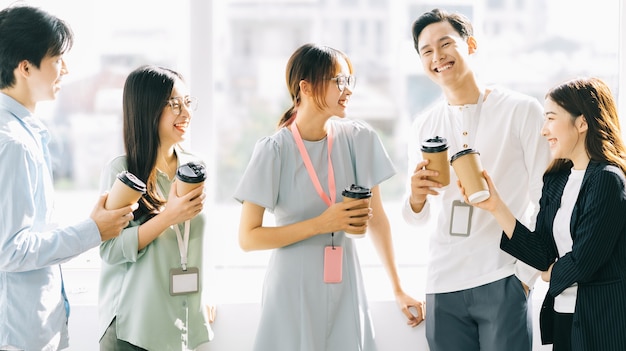 Pessoas do grupo de negócios estão conversando e bebendo café durante o recreio