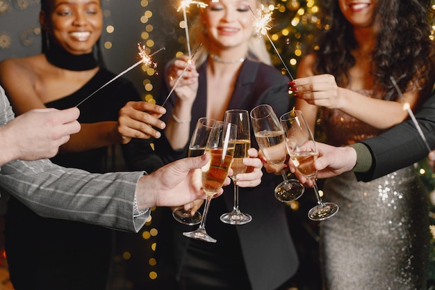 Pessoas do meio segurando uma taça com champanhe enquanto comemora o ano novo
