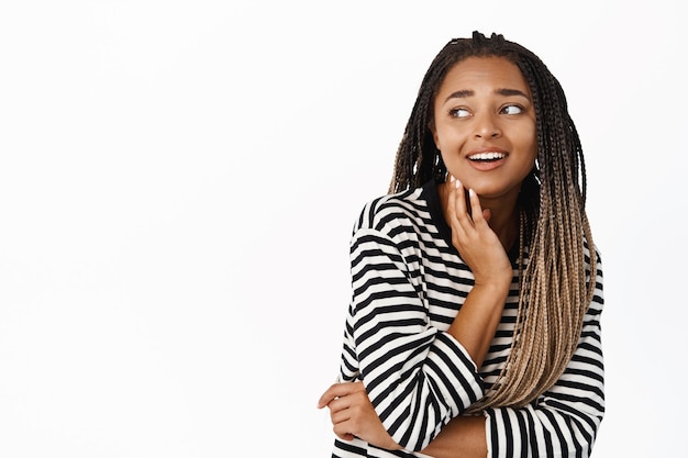 Pessoas e estilo de vida Jovem negra feliz olhando para o copyspace sorrindo e rindo reação ao fundo branco do anúncio