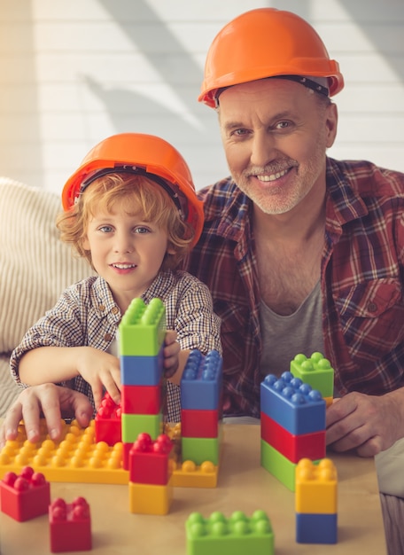 Pessoas em capacetes estão brincando com a construção em casa