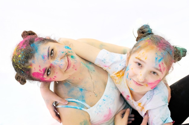 Pessoas em cores holi mãe e filha em cores brilhantes em seus rostos