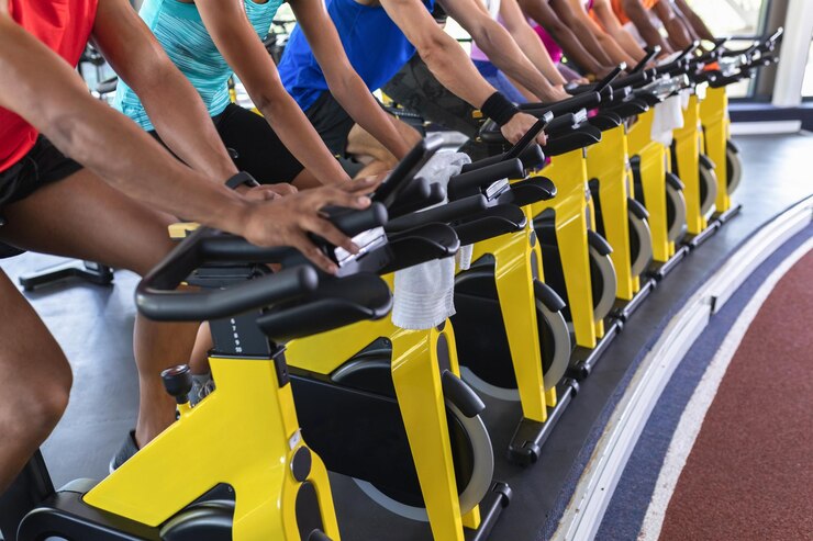 Foto pessoas em forma exercitando-se em bicicleta de exercício em um centro de fitness