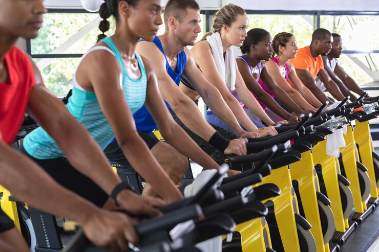 Foto pessoas em forma exercitando-se em bicicleta de exercício em um centro de fitness