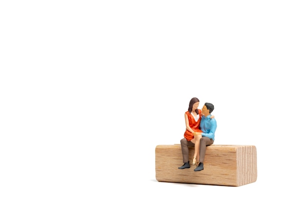 Pessoas em miniatura Casal sentado em uma cadeira de madeira e espaço para texto, conceito do Dia dos Namorados
