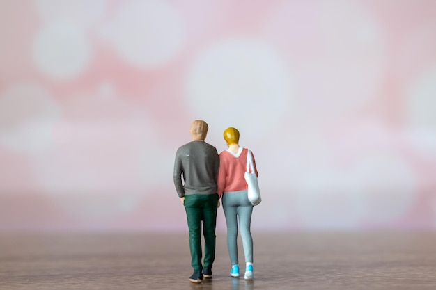 Pessoas em miniatura homem e mulher em pano casual juntos em fundo rosa