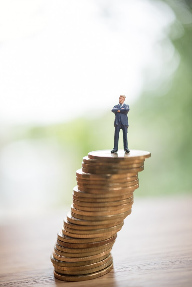 Pessoas em miniatura na pilha de moedas