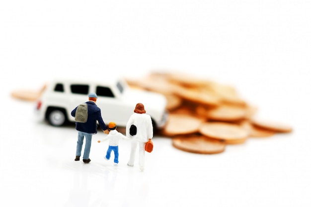 Foto pessoas em miniatura: pais e filhos caminhando para o modelo de carro com moedas. conceito de dinheiro, finanças e empréstimo de carro.