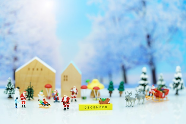 Pessoas em miniatura: Papai Noel com crianças brincando com neve e árvore de Natal.