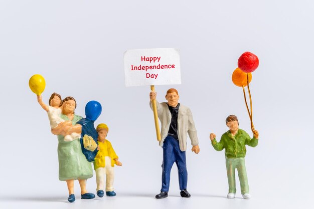 Pessoas em miniatura segurando bandeiras com a palavra feliz dia da independência