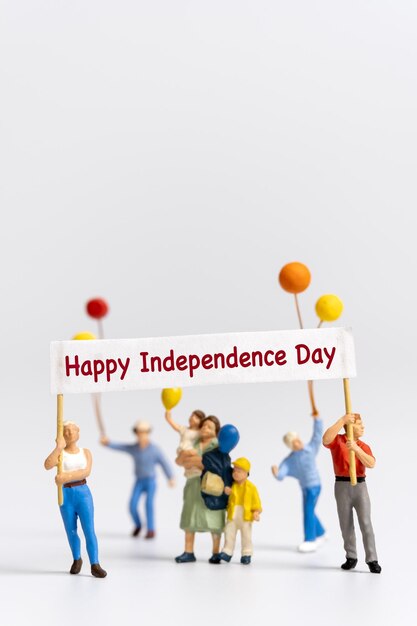 Pessoas em miniatura segurando bandeiras com a palavra feliz dia da independência