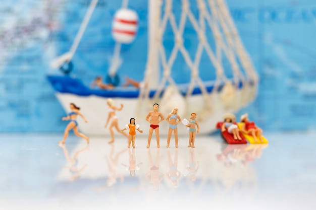 Pessoas em miniatura: turistas nadando com barco. Conceito de viajar.