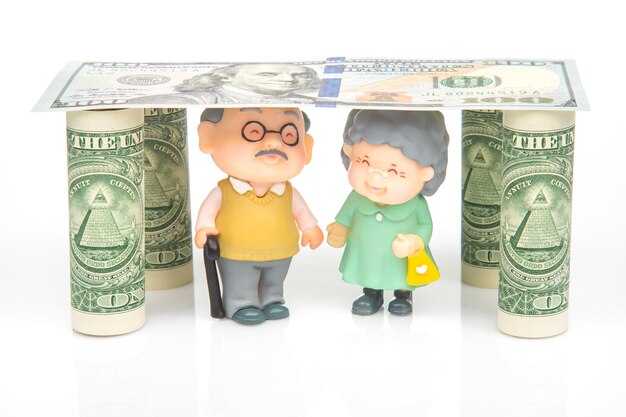 Pessoas em miniatura um casal de aposentados sob a casa dos dólares segurança financeira e pensão para o conceito idoso de independência financeira