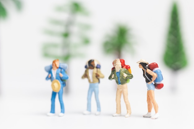 Pessoas em miniatura: Viajante com mochila andando em whitebackground,