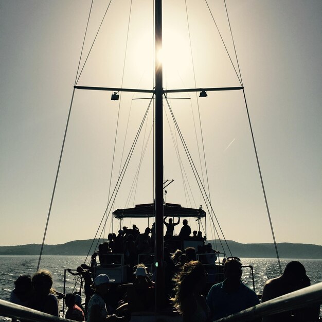 Foto pessoas em navio de vela contra o céu