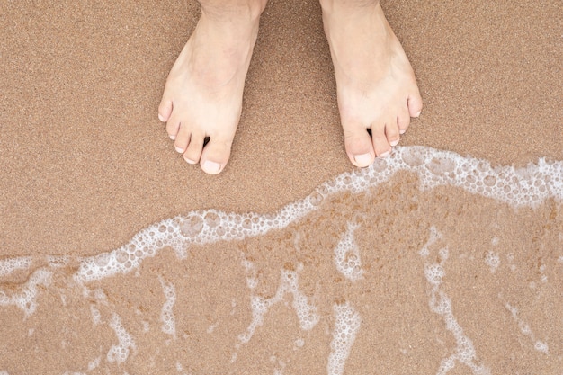 Pessoas em pé na praia no fundo de areia do mar