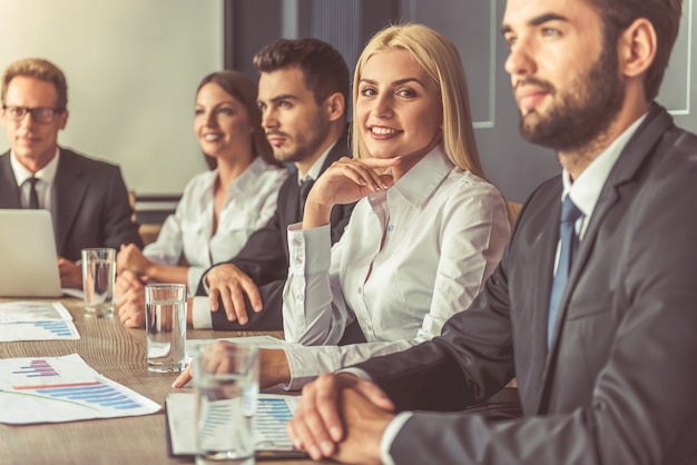 Pessoas em trajes formais estão participando da conferência.