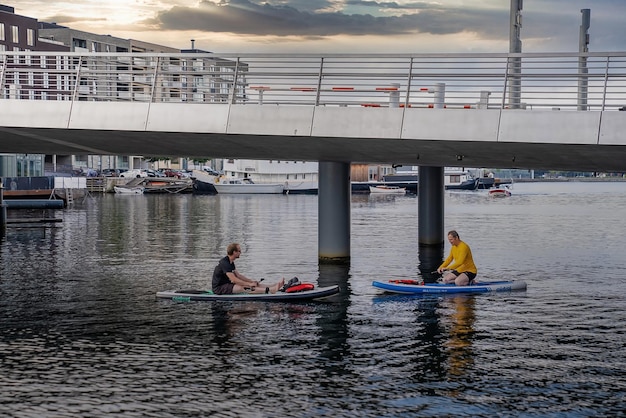 Pessoas em um sup paddle nos canais de copenhagen