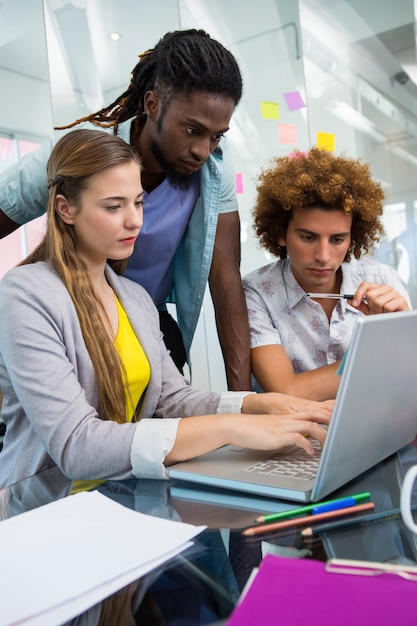 Pessoas empresárias criativas que usam o laptop na mesa