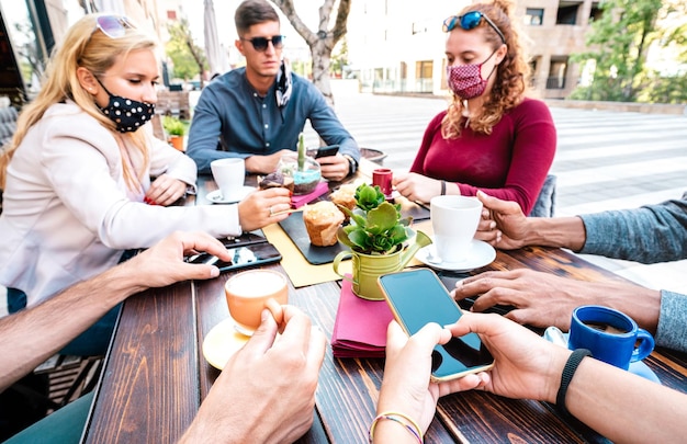 Pessoas entediadas usando telefones inteligentes móveis no café