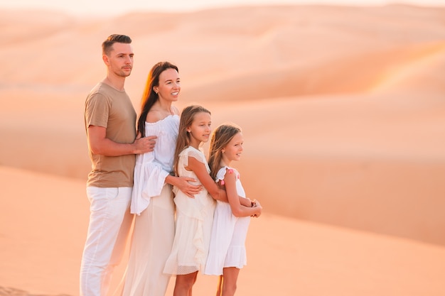 Pessoas entre dunas no deserto nos Emirados Árabes Unidos