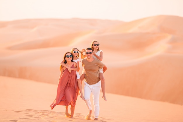 Pessoas entre dunas no deserto nos Emirados Árabes Unidos