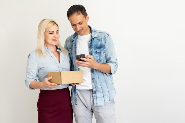 pessoas, entrega, transporte e conceito de serviço postal - casal feliz abrindo caixa de papelão ou pacote em casa