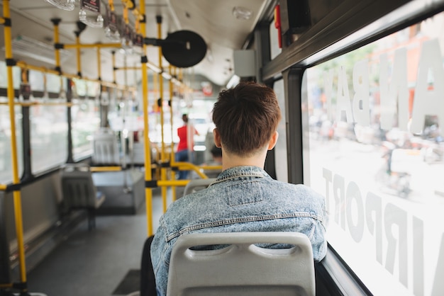 Foto pessoas, estilo de vida, viagens e transporte público. homem asiático em pé dentro do ônibus urbano.