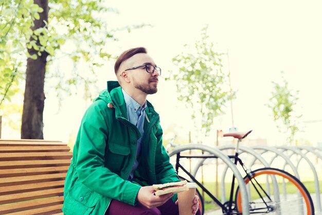 pessoas, estilo, lazer e estilo de vida - feliz jovem hipster com bicicleta de engrenagem fixa na rua da cidade