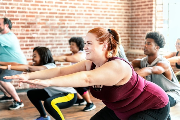 Pessoas fazendo agachamento na aula de fitness