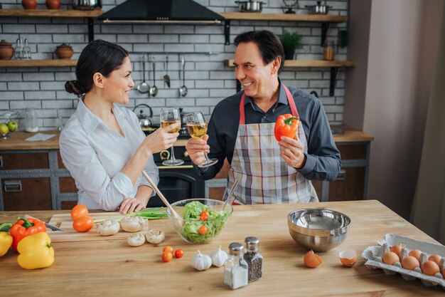 Pessoas felizes e positivas sentam juntos na cozinha à mesa