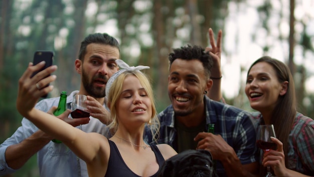 Pessoas felizes fazendo foto de grupo na floresta Amigos alegres posando de câmera