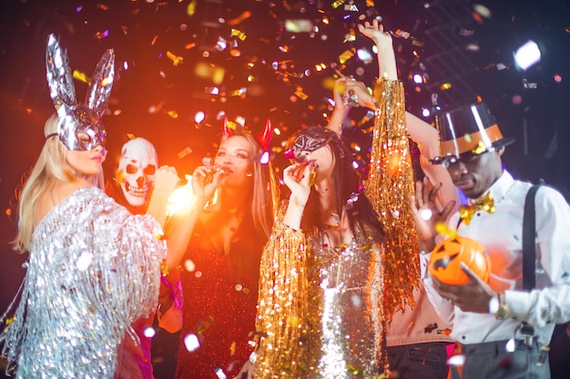 Pessoas felizes, homens e mulheres, mestiços dançando juntos na festa de Halloween