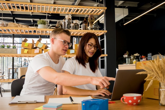 pessoas felizes, trabalhando com o laptop para o escritório de negócios de produto estoque de seleção on-line em casa