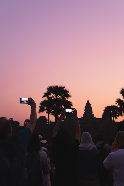 Foto pessoas fotografando em um concerto de música contra um céu claro durante o pôr do sol