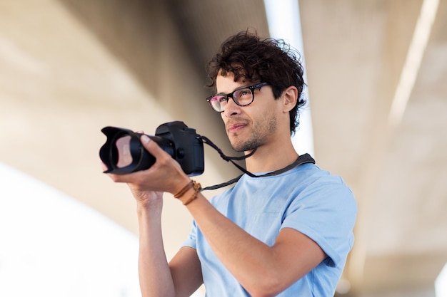 pessoas, fotografia, tecnologia, lazer e estilo de vida - fotógrafo com filmagem de câmera digital na cidade