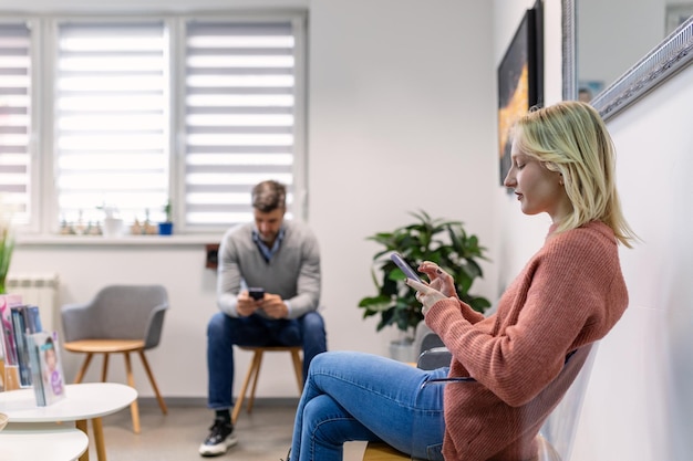 Pessoas homem e mulher sentados em uma fila e esperando uma consulta médica no hospital Conceito de sala de espera