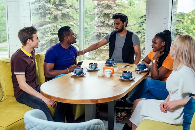 Pessoas internacionais bebendo chá (café) no café