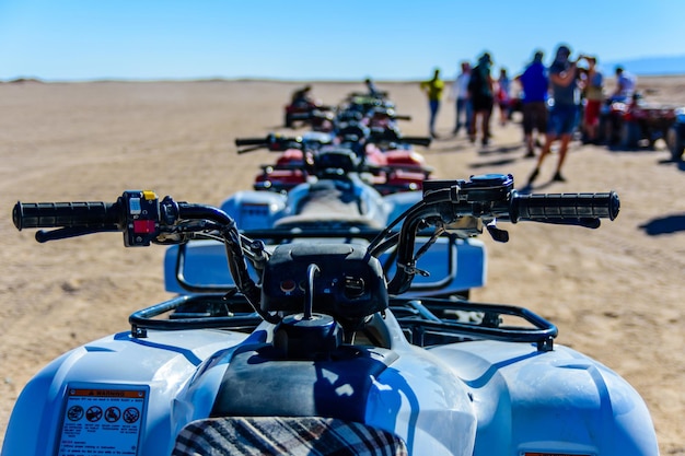 Pessoas irreconhecíveis perto de quadriciclos durante a viagem de safári no deserto árabe não muito longe da cidade de Hurghada, Egito