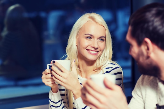 pessoas, lazer, comunicação, comer e beber conceito - casal feliz conhecendo e bebendo chá ou café no café