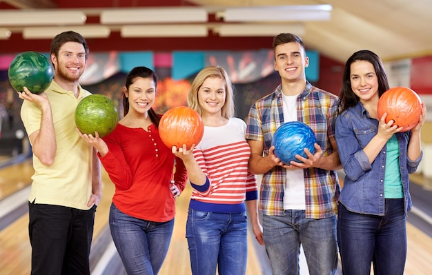 pessoas, lazer, esporte, amizade e conceito de entretenimento - amigos felizes no clube de boliche