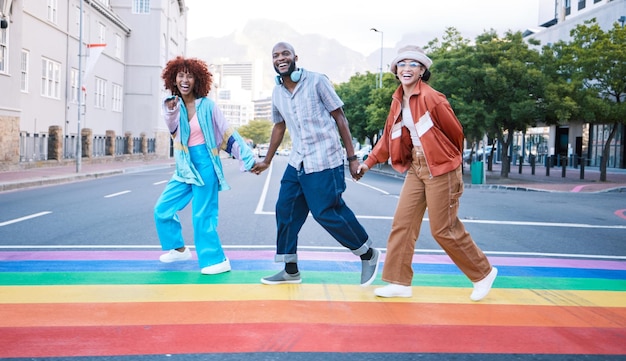 Pessoas LGBTQ de mãos dadas e arco-íris em pintura de rua e comunidade com felicidade e moda da geração Z na cidade Orgulho de streetwear urbano e apoio queer com aliado diferente ou único em retrato