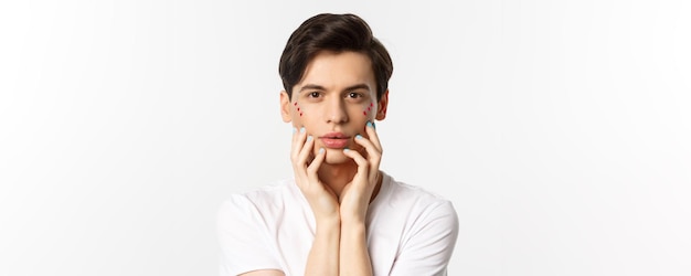 Pessoas lgbtq e conceito de beleza closeup de lindo homem queer tocando o rosto com dedos com azul