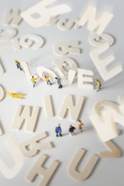 Pessoas (miniatura) preparando o dia dos namorados com o texto "AMOR", foco suave e seletivo em tons pastéis. Plano de fundo do dia dos namorados.